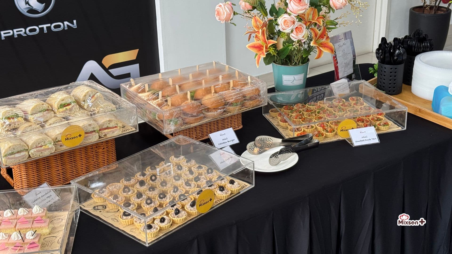 Canapé table with mini tarts and sandwiches at a showroom event