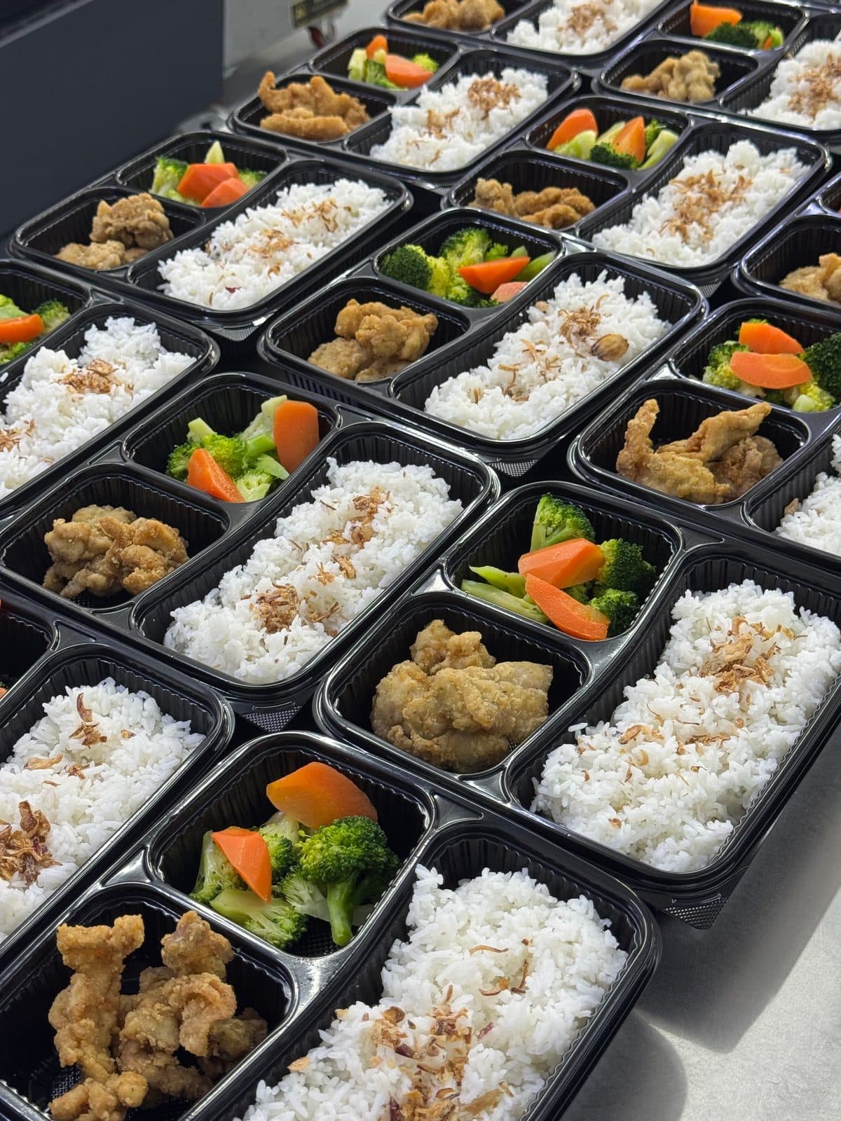 Three-compartment bento with rice, chicken and vegetables