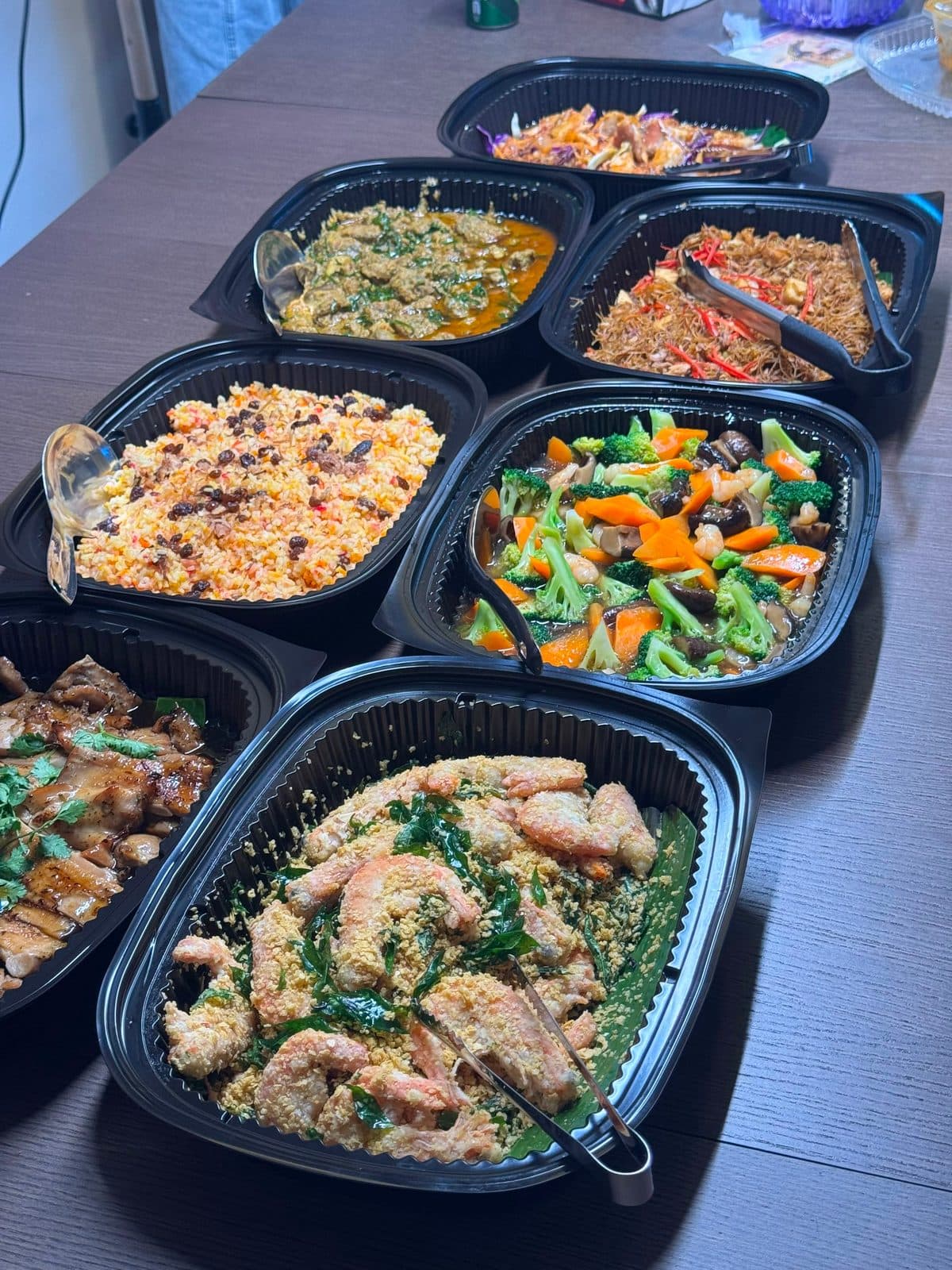 Mini buffet trays with cereal prawn, fried rice and stir-fried vegetables on a customer's table